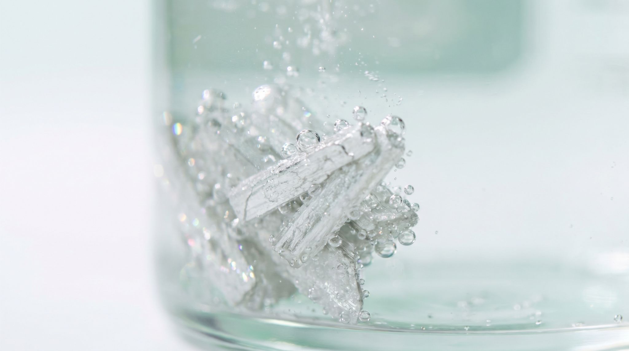Cristais de magnésio mineral a dissolver em água - suplementação NutriGenes Portugal